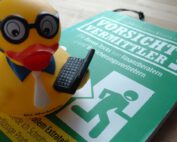 Ente mit Laptop auf dem Buch Vorsicht Vermittler